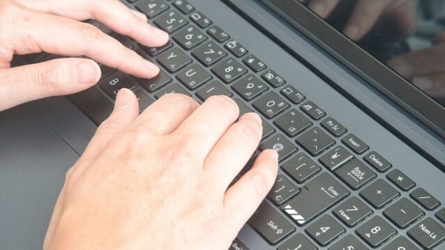 パソコンのキーボードをタイピングしている