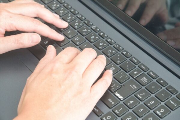 パソコンのキーボードをタイピングしている